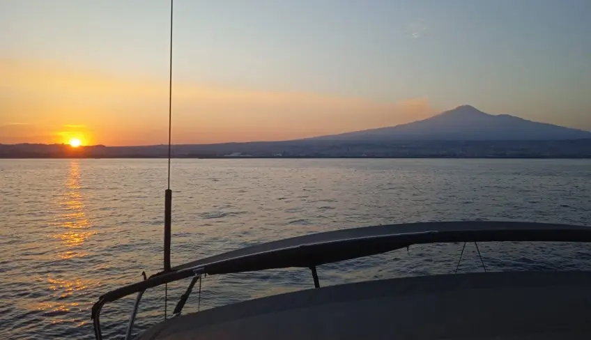 Tour in barca a vela al tramonto con vista sull'Etna, snorkeling nella Grotta di Ulisse e faraglioni di Acitrezza.