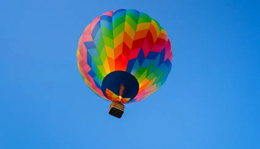 Mongolfiera che sorvola vigneti siciliani al tramonto
