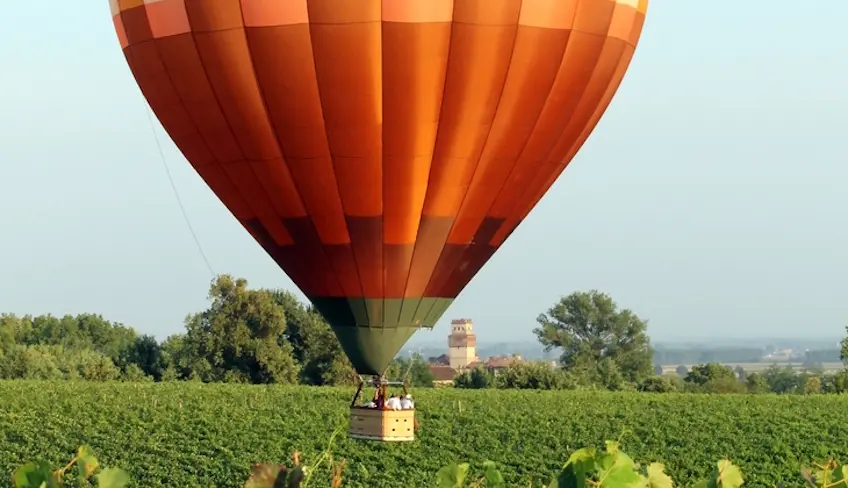 Mongolfiera che sorvola vigneti siciliani al tramonto
